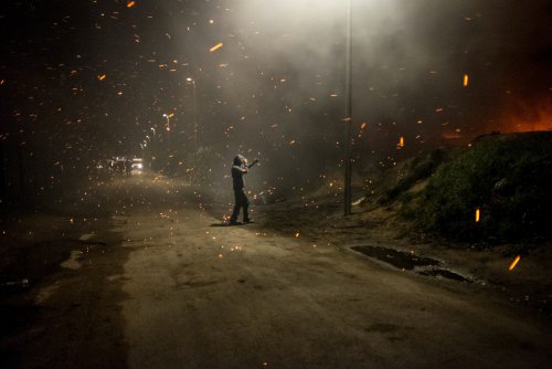 Sur le chemin des dunes, un militant prend quelques photos de l'incendie en cours, au soir du 13 novembre 2015. Les flammes s'élèvent à plus de dix mètres de hauteur
